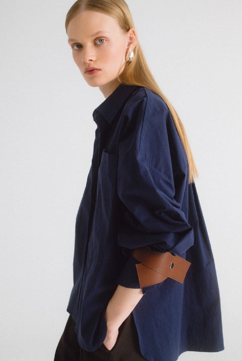 Camisa oversize azul con cuero marrón